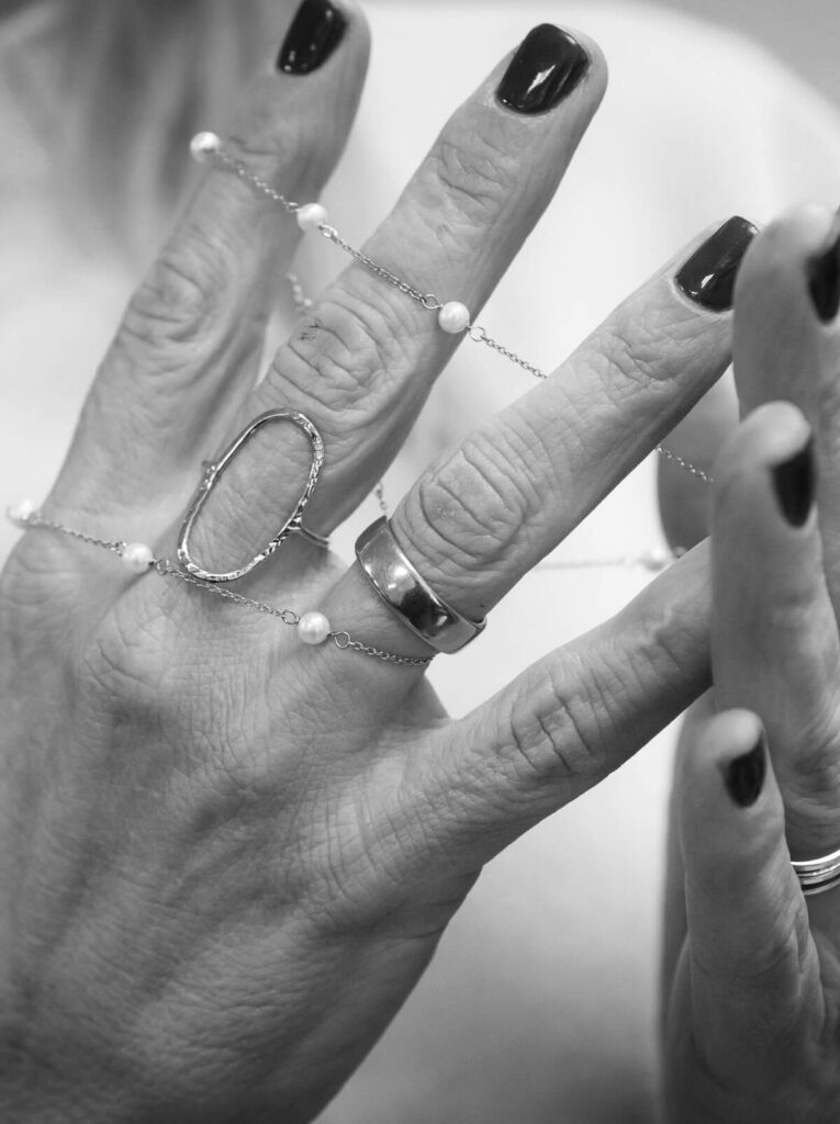 Manos con anillos y cadenas de oro y perlas de Nørreslet
