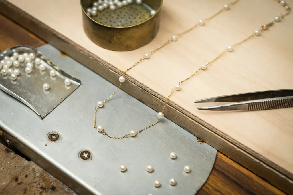 Cadenas de oro con perlas naturales sobre el banco del orfebre
