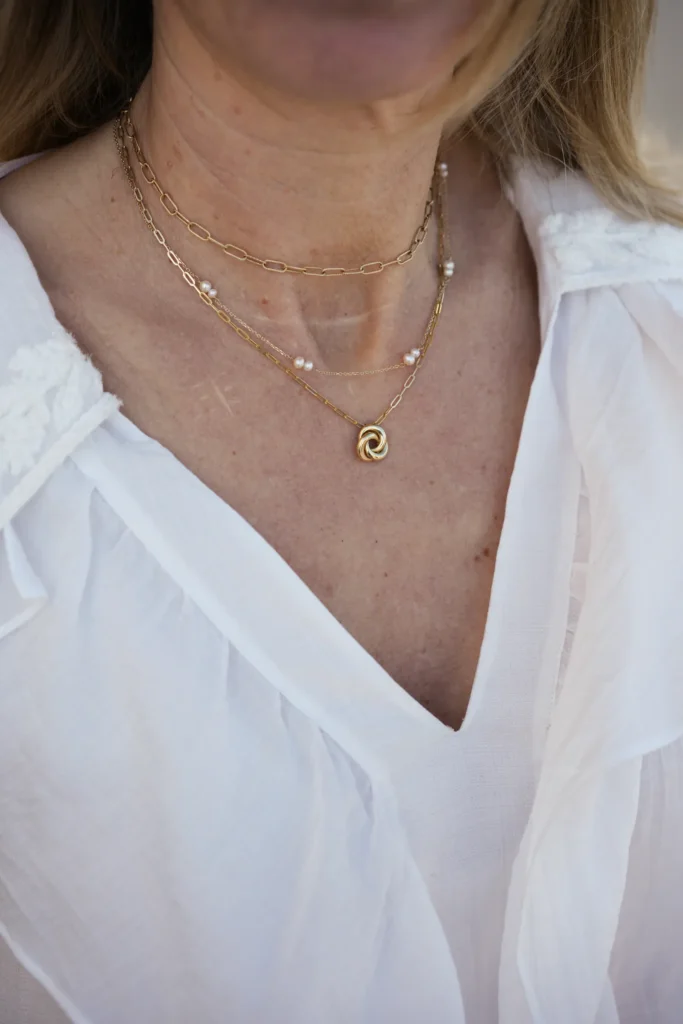Collares de oro en capas sobre blusa blanca